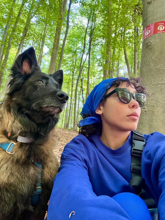 Nadège en selfie avec son chien malinois en forêt